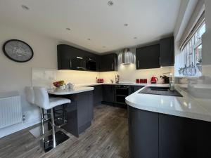 a kitchen with black cabinets and a counter top at Luxurious 4 bedroom home in the heart of the Cotswolds with Hot Tub! in Stow on the Wold