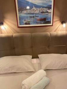 a bed with two pillows and a painting on the wall at Apartments Oliva in Poreč