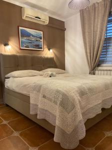 a bedroom with a bed with a blanket on it at Apartments Oliva in Poreč