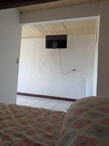 um quarto com uma parede com uma televisão numa parede em Departamentos Patricia em Alajuela