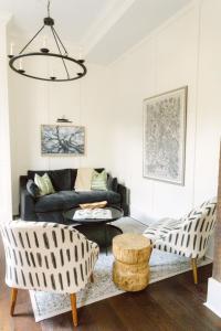a living room with a black couch and chairs at Guesthouse Charleston EAST 46 E in Charleston