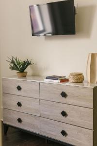 a dresser with a television on top of it at Guesthouse Charleston EAST 46 E in Charleston