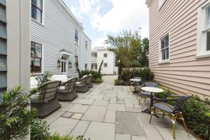 a patio with chairs and tables in a yard at Guesthouse Charleston EAST 46 E in Charleston