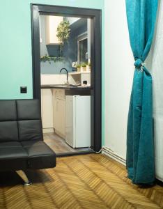 a living room with a chair and a kitchen at Green Vibes Central Brasov in Braşov