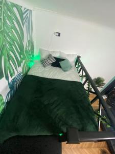 a bed in a room with a green and white wall at Green Vibes Central Brasov in Braşov
