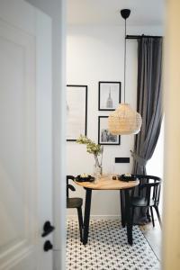 a dining room table with chairs and a pendant light at Poetry Apartments in the city center in Kharkiv