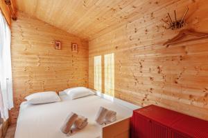 a bedroom with a white bed in a wooden wall at Calm chalet close to Cabourg center - Welkeys in Cabourg