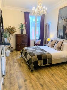 a bedroom with a bed and a chandelier at Bailie Royal Mile Apartment in Edinburgh