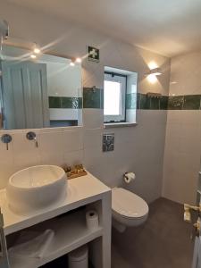 a bathroom with a sink and a toilet and a mirror at Chão da Velha - Casas de Campo in Nisa