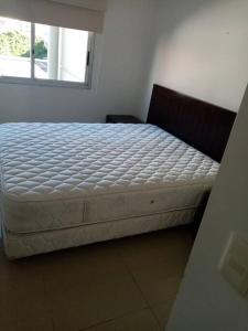 1 cama en un dormitorio con ventana en Moderno Apartamento en la Península, en Punta del Este