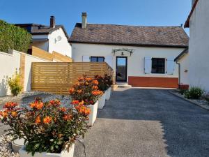a house with a fence and flowers in front of it at Maison cosy La Petite Cigogne en Baie de Somme in Boismont