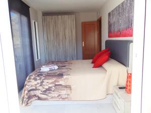 Un dormitorio con una cama con almohadas rojas. en Luxury EL BRILLANTE Apartament, en Fuengirola