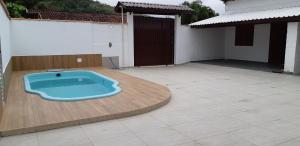 una vasca blu seduta in cima a un patio di 0006.04 - Maranduba - KitNet 1º Andar - 4 Pessoas - 3 Quadras Do Mar - Piscina Coletiva - WIFI a Ubatuba