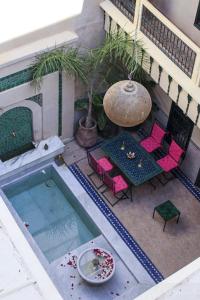 an overhead view of a pool with pink chairs and a table at Riad Dar Habiba by Garden Wonders in Marrakech