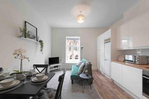uma cozinha e uma sala de jantar com mesa e cadeiras em Town center apartment in Bishops Stortford em Birchanger