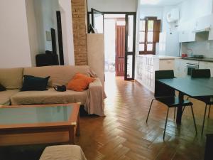 salon z kanapą i stołem w obiekcie Casa Sevilla Nervión-Centro w Sewilli
