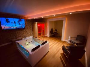 sala de estar con jacuzzi y TV. en Le Rêve d'une Nuit, en Bitche