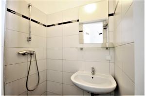 維也納的住宿－Modern flat with 2 rooms, close to Schönbrunn，白色的浴室设有水槽和淋浴。