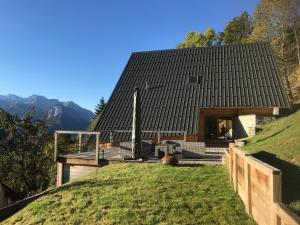 a house with a black roof on top of a hill at La grange à Gaspard in Allemont