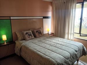 a bedroom with a large bed with two lamps at Tu Jardín Secreto in La Serena