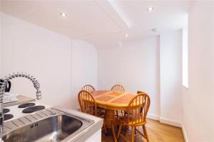 - une cuisine avec une table, des chaises et un évier dans l'établissement Bright Central London Apartments by DC London Rooms, à Londres