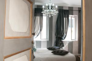 a bedroom with a bed and a chandelier at BIBI BOUTIQUE AREZZO Cartazucchero - Cioccolato in Arezzo