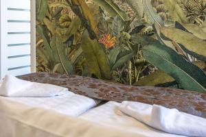 a bed with two pillows on it in front of a wallpaper at Flavius Spa Residence in Hévíz +41 photos