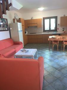 a living room with a red couch and a table at La Cinta in San Teodoro +15 photos