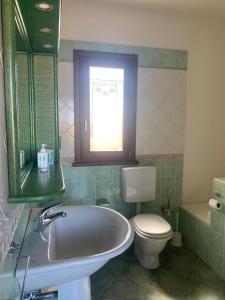 a bathroom with a sink and a toilet and a window at La Cinta in San Teodoro