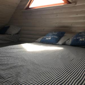 a large bed in a room with a window at Domek nad stawem RODOS in Raków