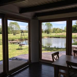 a screened in porch with a view of a lake at Domek nad stawem RODOS in Raków +23 photos