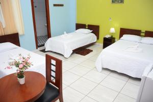 a hotel room with two beds and a table at Amazonia Hotel in Cobija