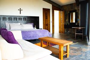 - une chambre avec un lit et une croix sur le mur dans l'établissement San Antonio Hotel Boutique, à Santiago Matatlán