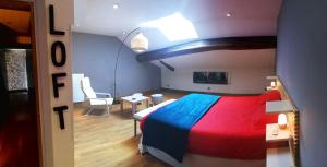 a bedroom with a colorful bed and a table at La Mirabelle des 3 Forêts in Bricon