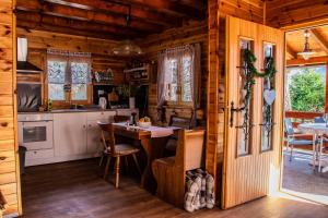 a kitchen and dining room in a log cabin at Petit chalet Belosevic in Kuželj