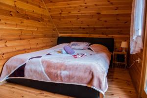 ein Schlafzimmer mit einem Bett in einem Blockhaus in der Unterkunft Petit chalet Belosevic in Kuželj