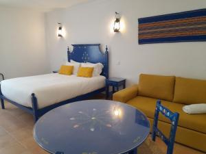 a room with a bed and a couch and a table at Casas da Minh'Alma in Reguengos de Monsaraz