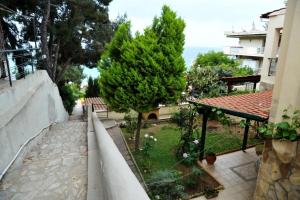 a view of a garden with trees and a building at Aiolos Home in Nea Moudania
