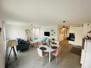 a kitchen and a living room with a table and chairs at Appartement Orchidées proche centre Ville in Colmar