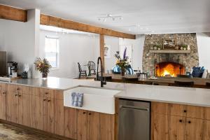 a kitchen with a sink and a fireplace at The Neighborhood Hotel Grand Beach in New Buffalo