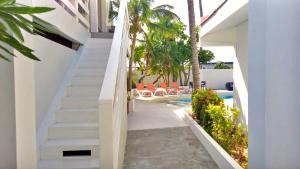 a staircase leading to a swimming pool with palm trees at Bubali Residence in Palm-Eagle Beach