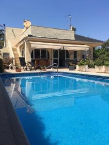 una gran piscina azul frente a una casa en PARADISE GARDEN, en Los Alcázares