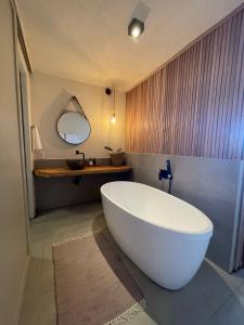 a large white tub in a bathroom with a mirror at Pousada da Pedra Rifaina in Rifaina