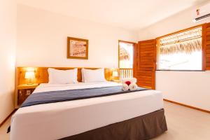 a bedroom with a large bed and a window at UNKUÉ POUSADA FLATS in Jericoacoara