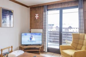 a living room with a television and a chair at Appartement Les lutins - incredible view of Mont Blanc in Chamonix-Mont-Blanc +5 photos