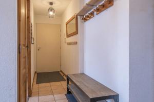 a hallway with a wooden bench next to a wall at Appartement Les lutins - incredible view of Mont Blanc in Chamonix-Mont-Blanc