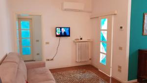 un salon avec un canapé et une télévision sur un mur dans l'établissement Residenza Emilia, à Venise
