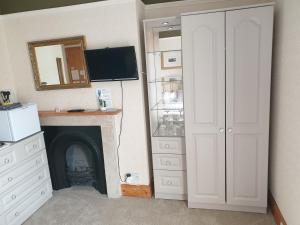 a room with a fireplace and a white closet at The Pathway Guesthouse in Whitby