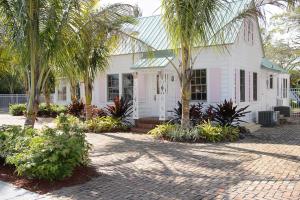 a white house with palm trees in front of it at Old Colorado Inn in Stuart