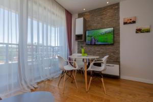 ズラティボールにあるTime Out Wine apartmanのテーブルと椅子とテレビのあるダイニングルーム